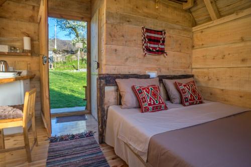 a bedroom with a bed in a wooden cabin at Djurdjevina Family Farm in Kolašin