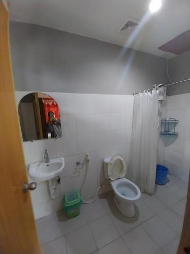ein Badezimmer mit einem WC, einem Waschbecken und einem Spiegel in der Unterkunft TAVERN ROOMS FOR RENT in Panglao