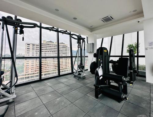a gym with exercise equipment in a building with windows at Prime Comfort Seaview with Netflix and Water Filter near Georgetown in Jelutong