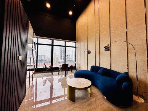 a living room with a blue couch and a table at Prime Comfort Seaview with Netflix and Water Filter near Georgetown in Jelutong