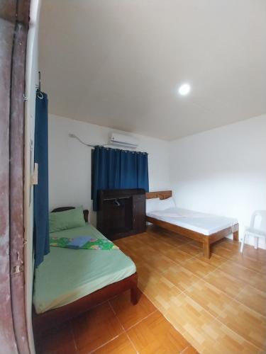 um quarto com duas camas e uma mesa em TAVERN ROOMS FOR RENT em Panglao City