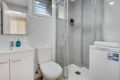 a white bathroom with a toilet and a shower at Vistamarina B105 by IVI Real Estate in Torremolinos
