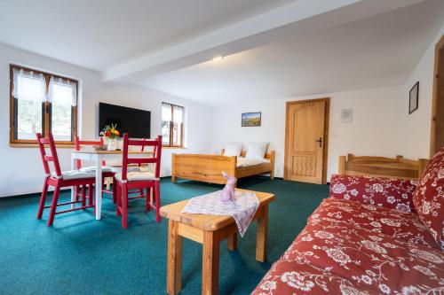 a living room with a couch and a table at Penzion Na Výšinkách, Jetřichovice, České Švýcarsko in Jetřichovice