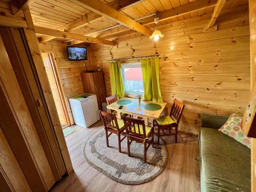 ein Esszimmer mit einem Tisch und Stühlen in einer Blockhütte in der Unterkunft Siedlik Agroturystyka - spokojne miejsce dla Ciebie i Twojej rodziny in Lidzbark