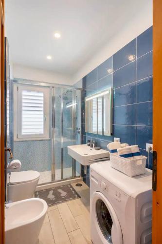 a bathroom with a washing machine and a sink at Maison Eva in Sorrento
