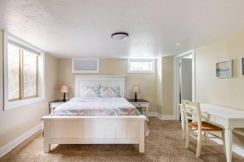 a bedroom with a white bed and a desk and a table at State Street Cottage, Suite 1 in Pullman