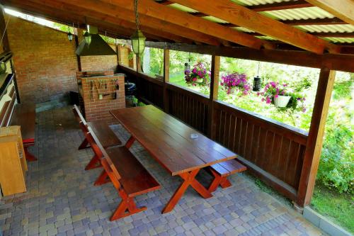 una mesa de madera y sillas en un porche cubierto en GoGreen Hotel, en Rząska