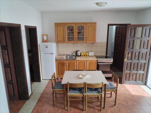une cuisine avec une table et des chaises et un réfrigérateur blanc dans l'établissement Apartment Ivana, à Kotor