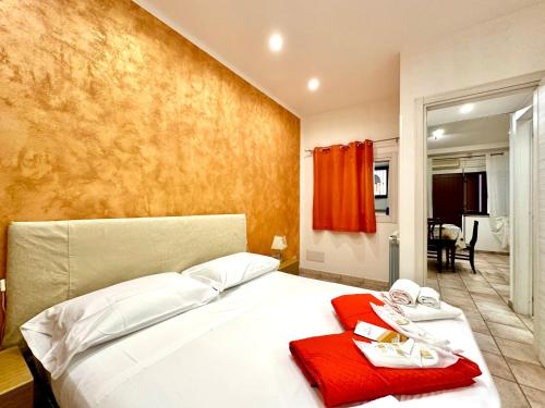 a bedroom with a white bed with a red towel on it at Il Rifugio Del Marinaio By Housilia in Cefalù