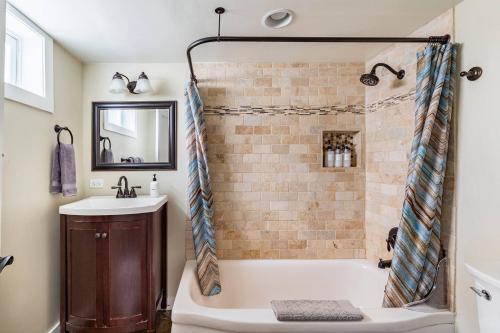 a bathroom with a bath tub and a sink at State Street Cottage, Suite 1 in Pullman