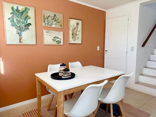 ein Esszimmer mit einem weißen Tisch und weißen Stühlen in der Unterkunft Duplex zona calvario in Tandil