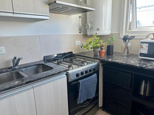 eine Küche mit Herd und Spüle in der Unterkunft Duplex zona calvario in Tandil