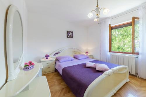 ein weißes Schlafzimmer mit einem Bett und einem Fenster in der Unterkunft House FELICIA in Kršan