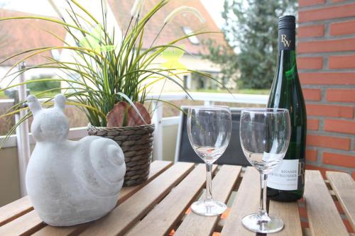 un tavolo con due bicchieri e una bottiglia di vino di Ferienwohnung Strandfee, App 01 in ruhiger strandnaher Lage a Grömitz