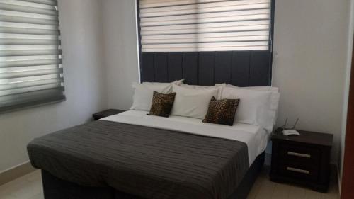 a bedroom with a large bed with white sheets and pillows at Relax Waterfront Apartments. in Bijilo