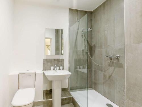 a bathroom with a toilet sink and a shower at 5 Bed in Sawtry 86894 in Sawtry