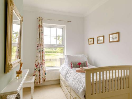 a baby bedroom with a crib and a window at 5 Bed in Sawtry 86894 in Sawtry