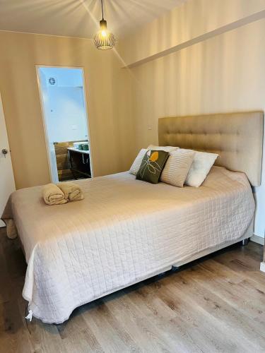 a large bed in a bedroom with a mirror at MONTERRICO POLO APARTS #13 - DPTO 2 dorm - Frente Embajada USA in Lima