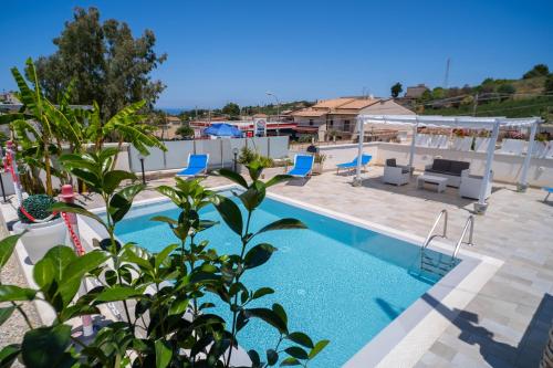 une piscine avec des chaises et une terrasse avec dans l'établissement holiday inn endless summer, à Alcamo