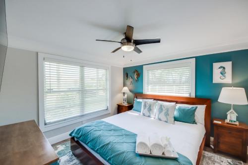 a bedroom with a bed with blue walls and a ceiling fan at Punta Gorda Getaway with Canal Access and Lanai! in Punta Gorda