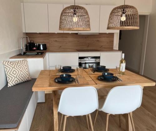 eine Küche mit einem Holztisch und weißen Stühlen in der Unterkunft Amselnest - b42499 in Rimsting