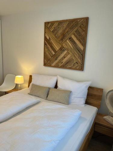 a bed with two white pillows and a picture on the wall at Amselnest in Rimsting