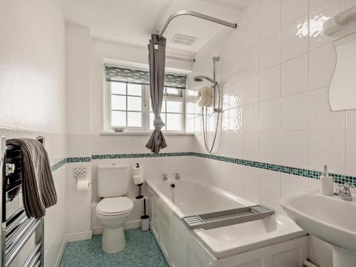 a bathroom with a tub and a toilet and a sink at 2 Bed in Westward Ho 46824 in Westward Ho