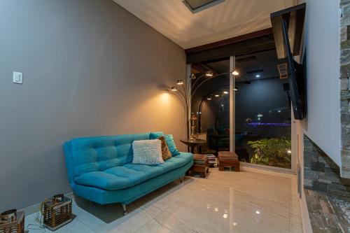 a blue couch in a living room with a window at Malugo Campestre in Pereira