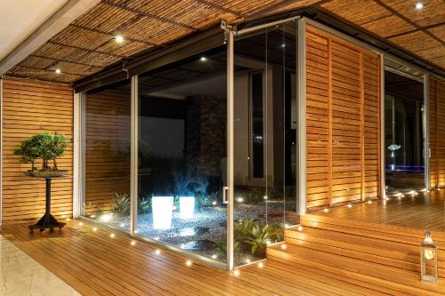 a glass house with a fountain on a wooden deck at Malugo Campestre in Pereira