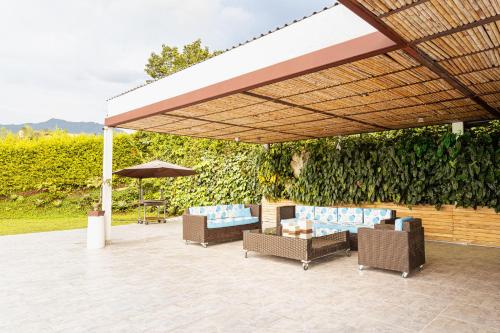 a pavilion with chairs and an umbrella on a patio at Malugo Campestre in Pereira
