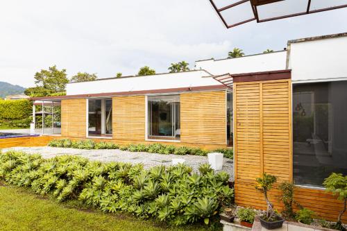 a house with wooden siding and a garden at Malugo Campestre in Pereira
