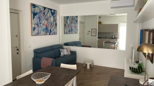 un salon avec un canapé bleu et un miroir dans l'établissement Appartamento San Gallo Cremona Centro, à Crémone