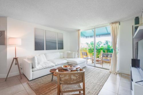 a living room with a white couch and a table at Lux Condo at Yacht Club 10 min from Beach in Miami