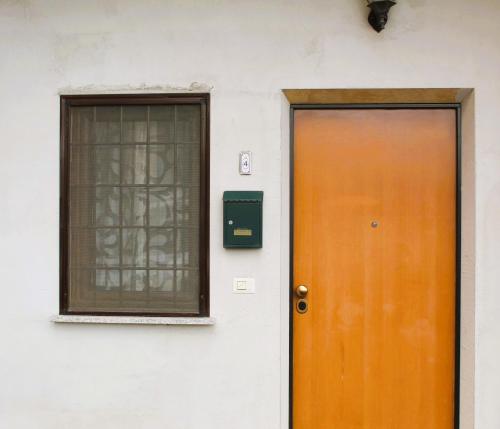 a orange door and a window on a building at Ale Apartment in Rome
