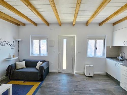 a living room with a couch and a kitchen at Casa de Lupa - Camariñas - Costa da Morte in A Coruña