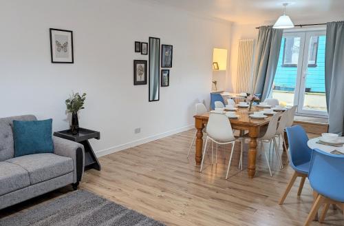 a living room with a dining room table and a couch at Erradale in Campbeltown