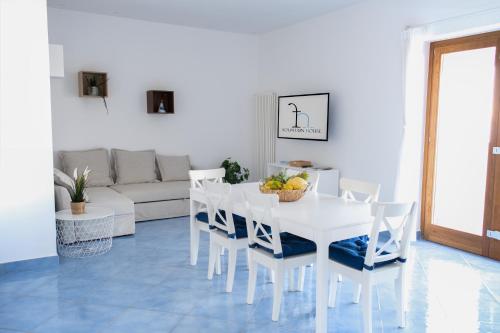 ein weißes Esszimmer mit einem weißen Tisch und Stühlen in der Unterkunft Fountain House Sorrento in Sant'Agnello