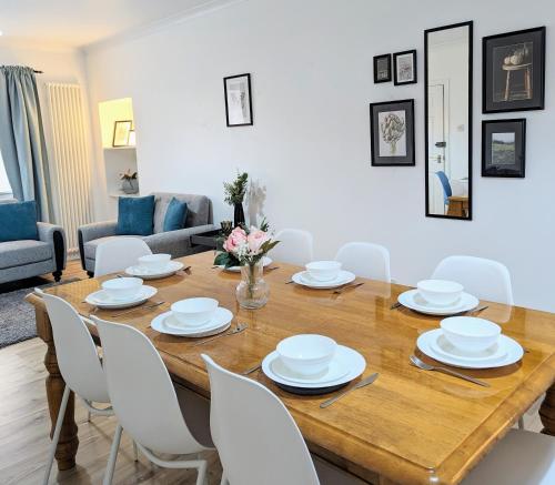 una sala da pranzo con tavolo in legno e sedie bianche di Erradale a Campbeltown