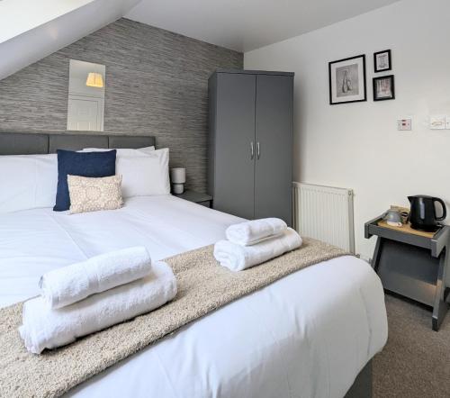 a bedroom with a large white bed with towels on it at Erradale in Campbeltown