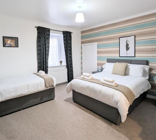 a bedroom with two beds and a window at Erradale in Campbeltown