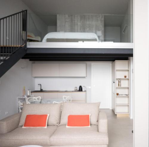 salon z kanapą i łóżkiem na podwyższeniu w obiekcie Panorama Loft Apartments w mieście Stresa