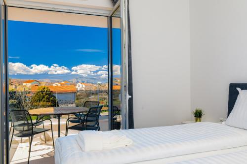 - une chambre avec un lit et un balcon avec une table dans l'établissement Apartment Mialis, à Krk