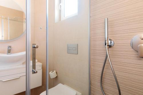 La salle de bains est pourvue d'une douche, de toilettes et d'un lavabo. dans l'établissement Apartment Mialis, à Krk