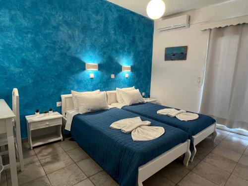 Un dormitorio azul con una cama con toallas. en Villa Pavlina en Karterados
