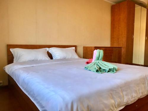 a white bed with a towel on top of it at City Center Apartment in Karagandy