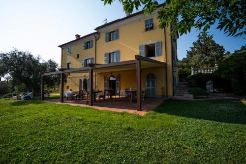 a large yellow house with a large patio at Locanda De Banchieri in Fosdinovo