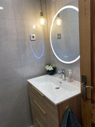 a bathroom with a sink and a mirror at Da Laura deux pièces proche de cannes in Le Cannet
