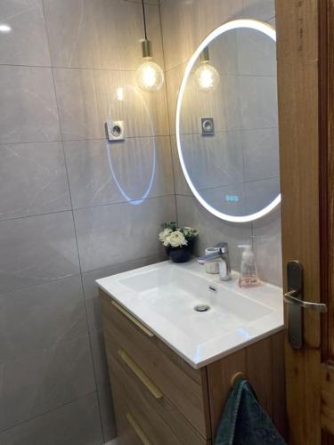 une salle de bain avec un lavabo et un miroir dans l'établissement Da Laura deux pièces proche de cannes, au Cannet