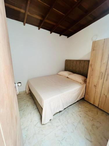 1 dormitorio con 1 cama y armario de madera en El Noral en Medellín