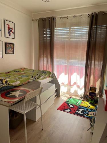 a bedroom with a bed and a desk and a window at Da Laura deux pièces proche de cannes in Le Cannet